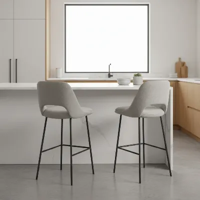 A pair of comfortable, upholstered bar stools with backrests and footrests in a modern kitchen setting, illustrating style and ergonomics.