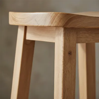 Close-up of the Pottery Barn Tibetan Bar Stool's wood joinery and finish, emphasizing its quality construction.