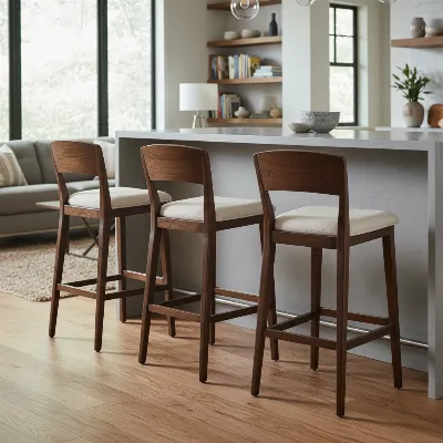 A set of three elegant wooden bar stools with backs at a rustic-modern kitchen counter, emphasizing natural materials and comfort.